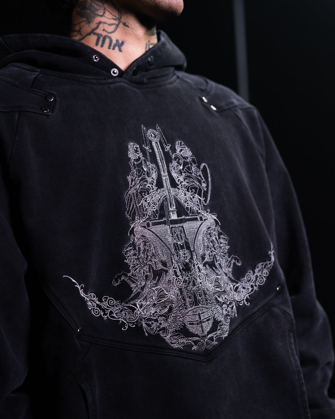 Black hoodie with intricate white embroidered design on a black background
