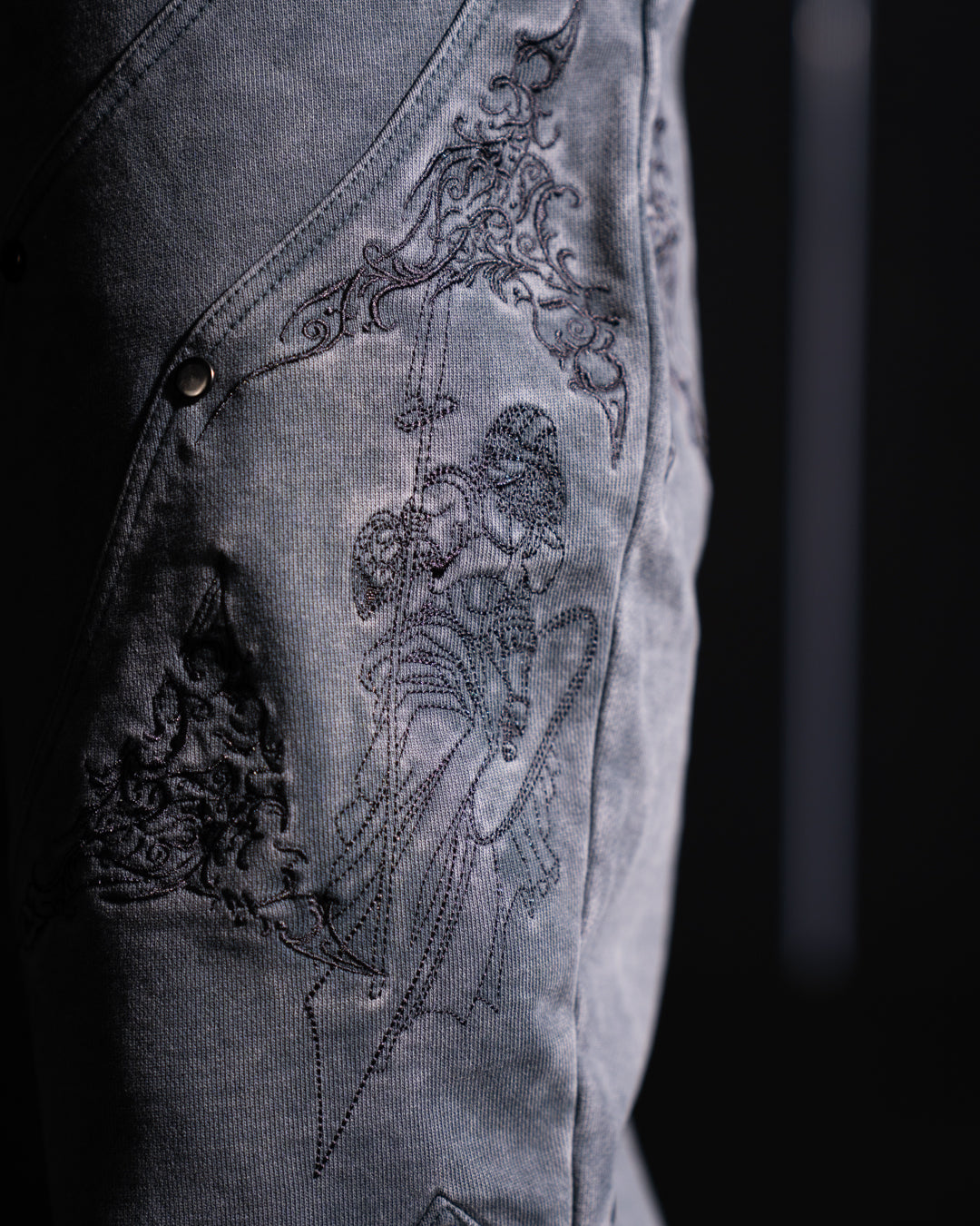 Embroidered design on a dark grey fabric background