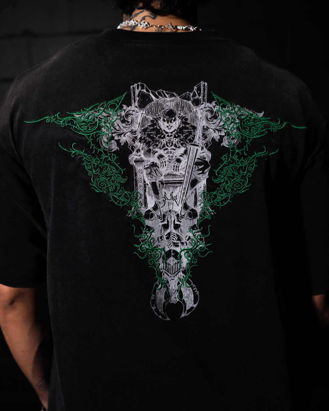 Black t-shirt with a detailed graphic design on the back, worn by a person.