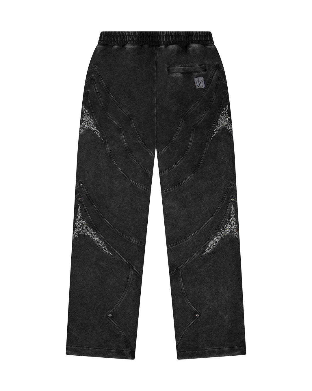 Back of black sweatpants with embroidery patterns on sides, right side pocket on a white background.