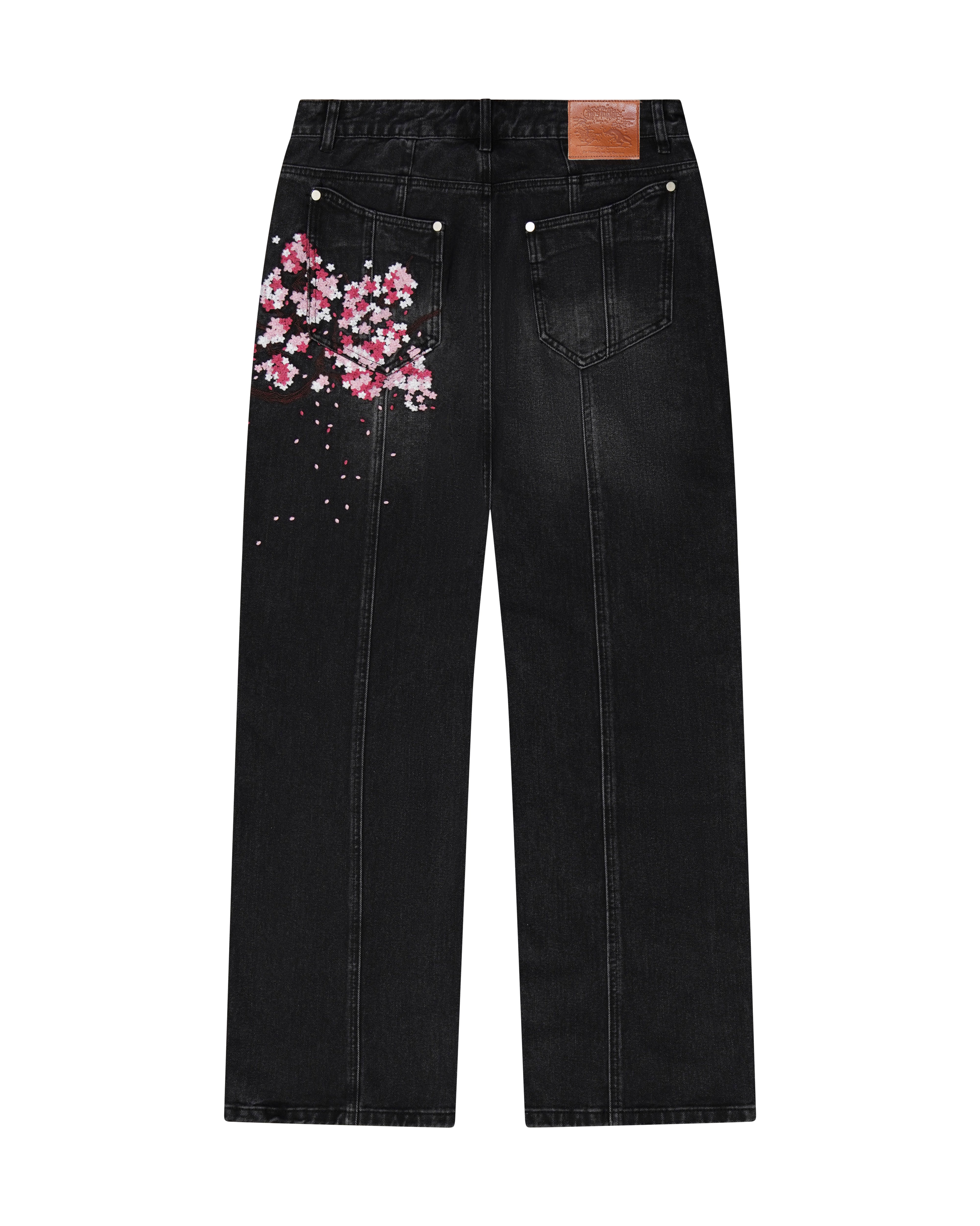 Black denim jeans with cherry blossom floral embroidery and armored inspired paneling.
