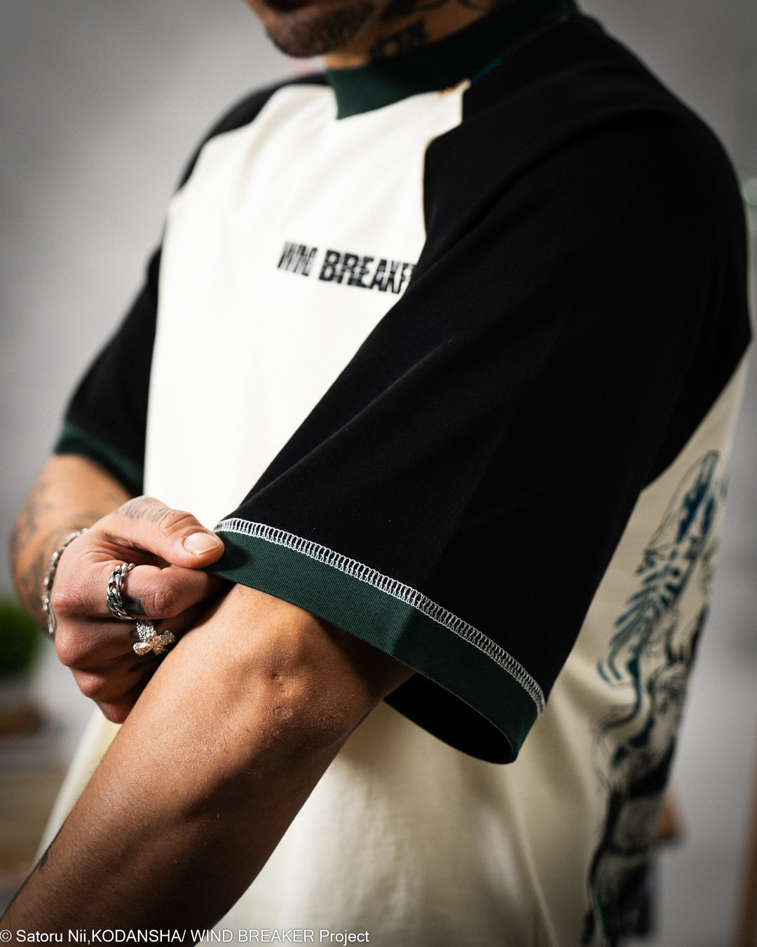 Person wearing a black and white t-shirt with text, focusing on the sleeve.