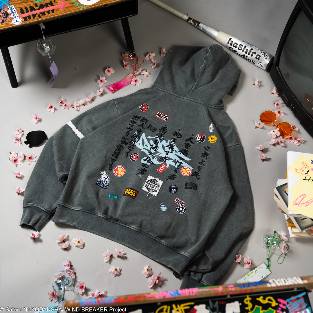 Gray hoodie with colorful patches on a gray surface with decorative items