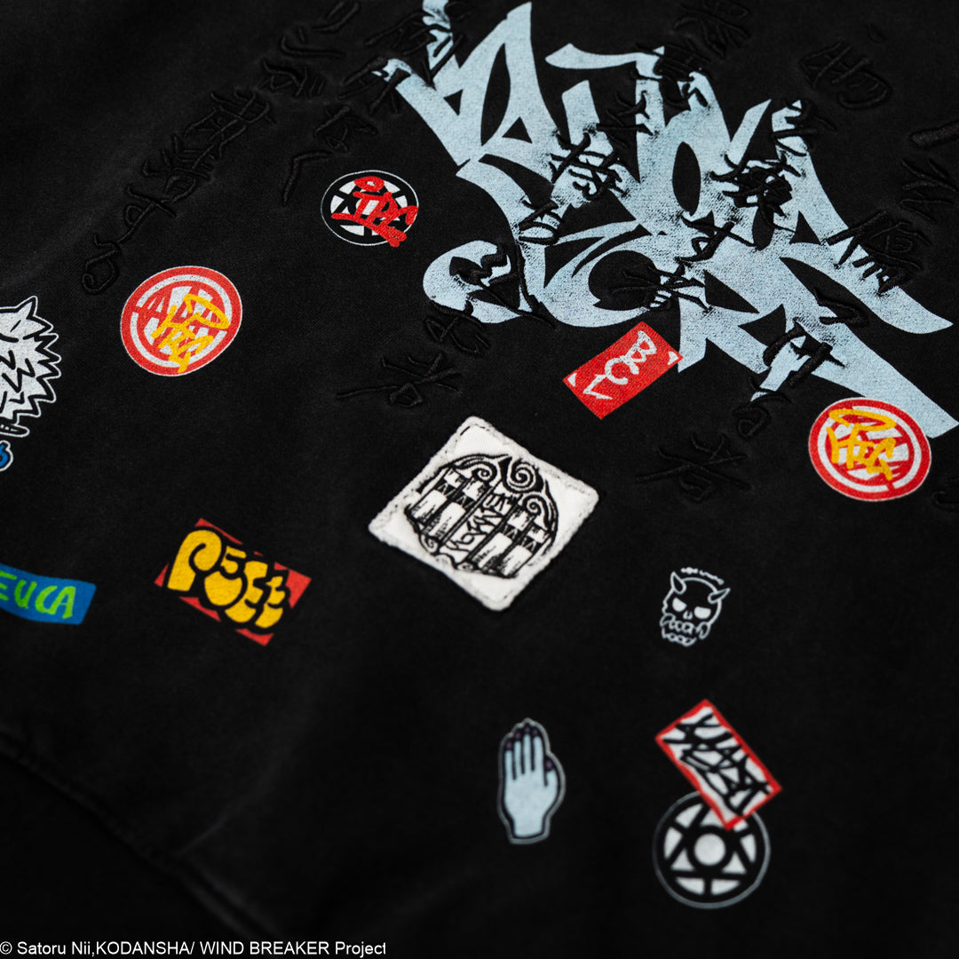 Black shirt with various colorful logos and patches.