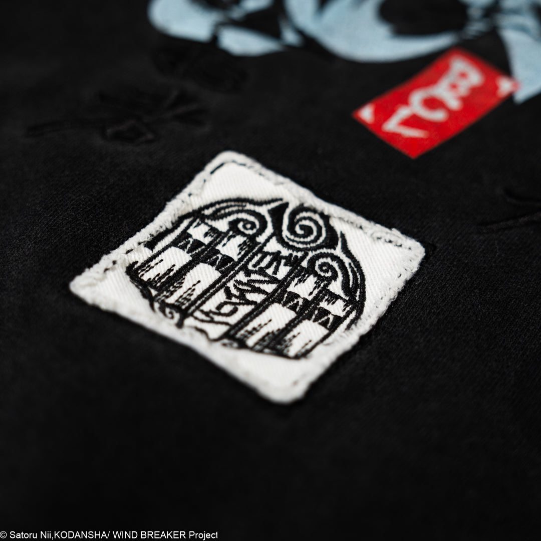 Close-up of a black t-shirt with a white logo patch.