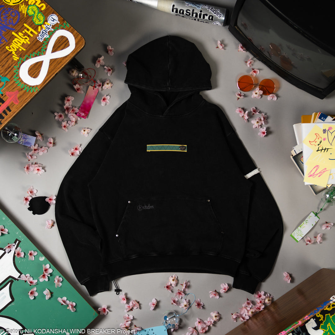 Black hoodie with a gold and green patch on the front.