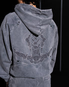 Gray hoodie with embroidery design on the back against a dark background