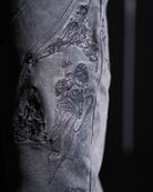 Embroidered design on a dark grey fabric background