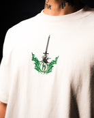 White t-shirt with a green and black graphic design on a dark background
