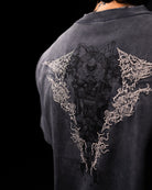 grey shirt with intricate white designs on the back against a black background