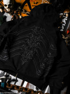 Black jacket with a white spine design on a dark background