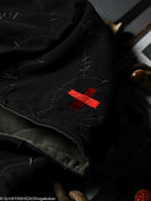 Black hood with red cross embroidery on a dark background