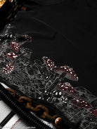 Close-up of black t-shirt hem with mushroom designs on a dark background