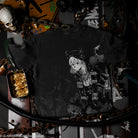 Black t-shirt with anime character design on a dark background with various items.