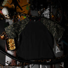 Black t-shirt on a dark surface with various items. 