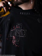Black shirt with white embroidered design on the front. 