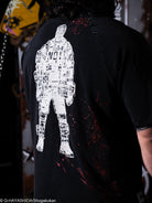 Black t-shirt with white graphic design on the back, worn by a person.