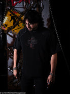 Person wearing a black t-shirt with a graphic design in a dark setting