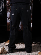 Person wearing black cargo pants with a brand logo with two back pockets. 