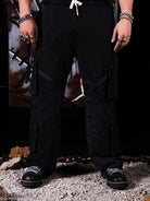 Person wearing black sweatpants and shoes in a dark setting