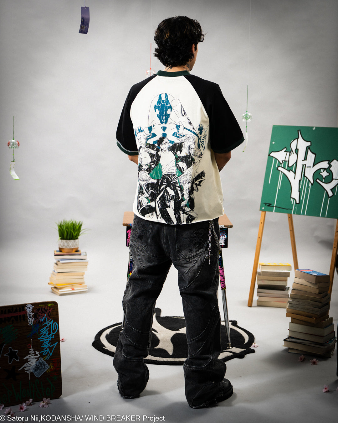 Person wearing a black and white graphic t-shirt in an art studio setting