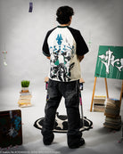 Person wearing a black and white graphic t-shirt in an art studio setting