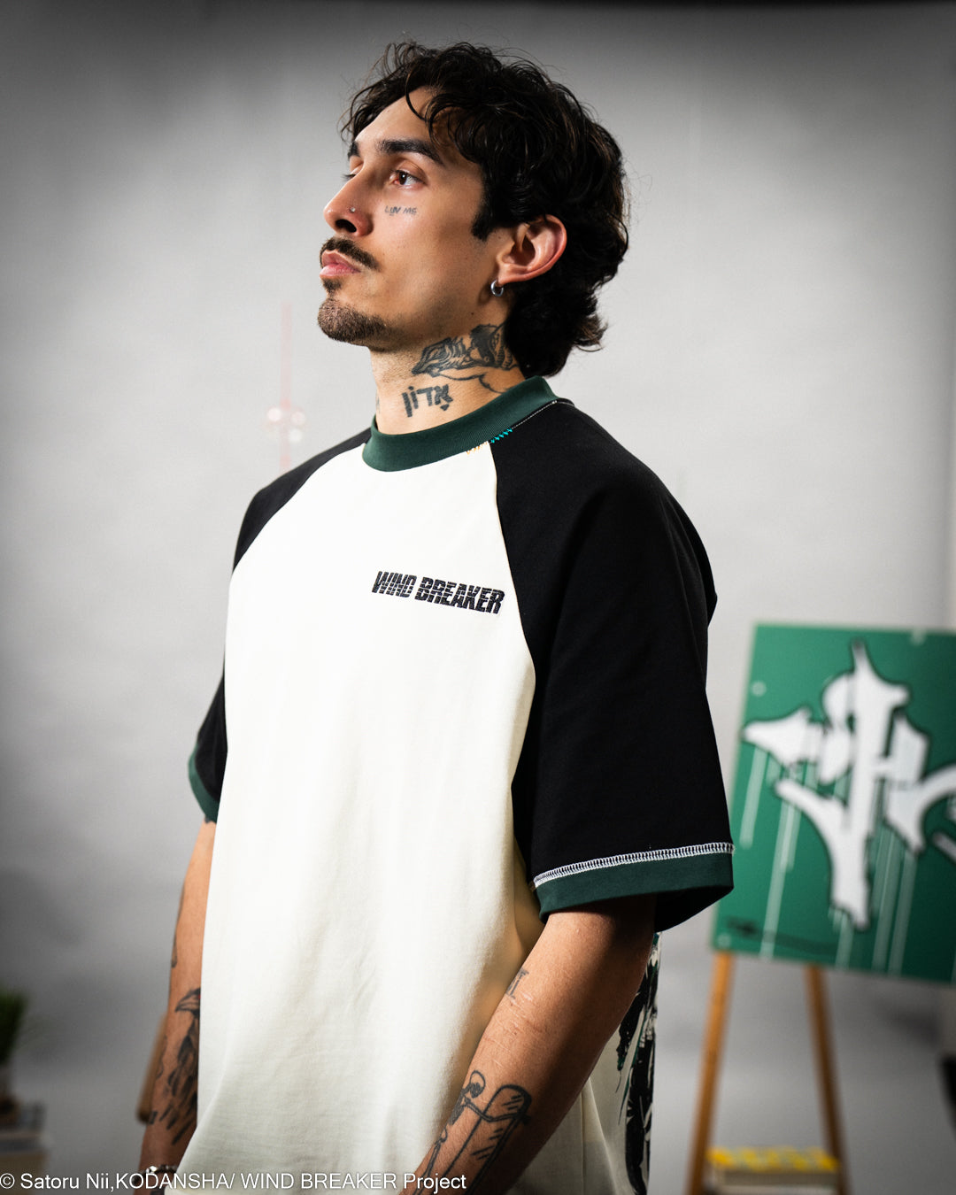Person wearing a black and white baseball shirt with 'WIND BREAKER' text, standing against a gray background.