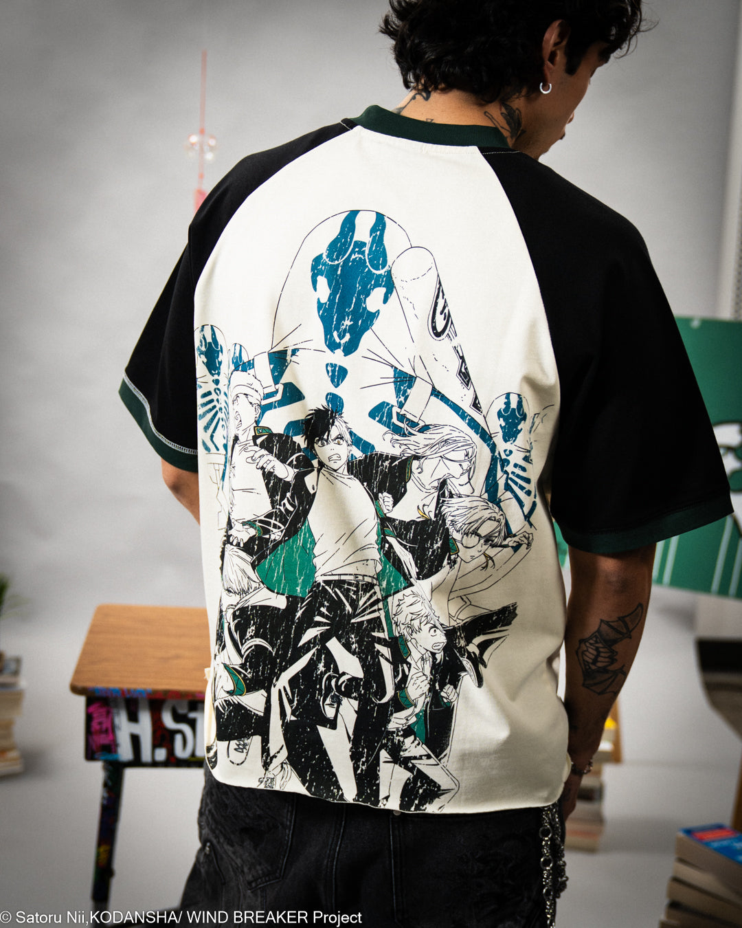 Person wearing a black and white baseball shirt with graphic design, standing in an indoor setting.