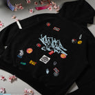 Black hoodie with various colorful patches on a light gray background with decorative elements.