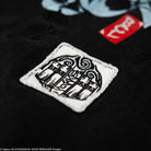 Close-up of a black t-shirt with a white logo patch. 
