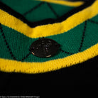 Close-up of a green, yellow, and black striped fabric with a button in the center.