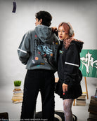 Two people wearing hoodies with visible branding in an indoor setting.