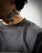 Person wearing a dark gray shirt with a small logo.