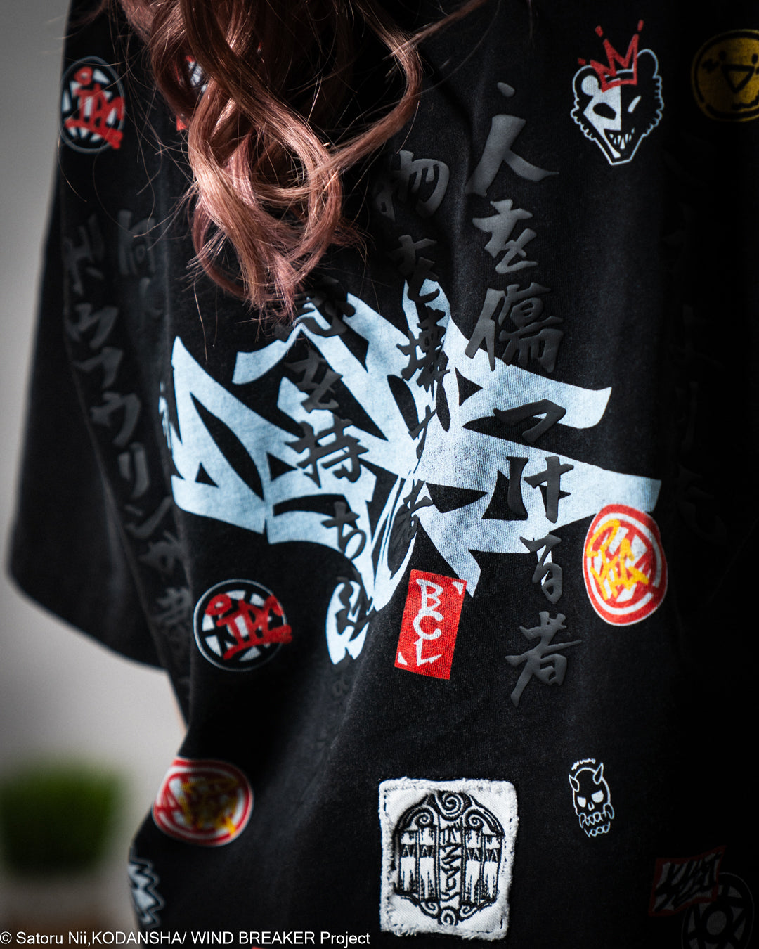 Black t-shirt  with various patches and designs, including text and symbols.